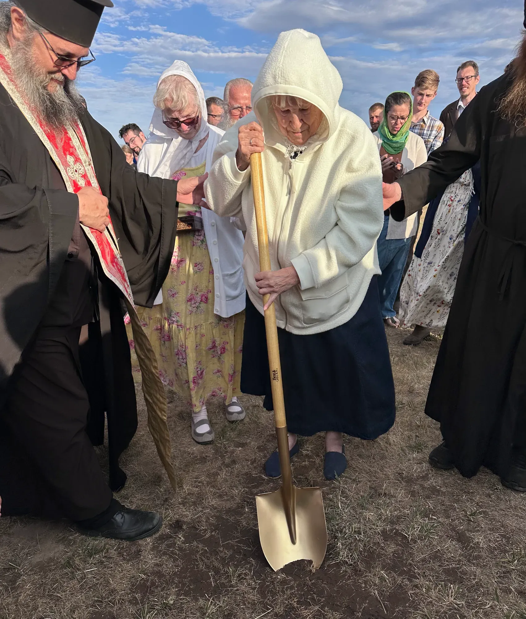 A parishioner turns the first shovelful of earth at the groundbreaking